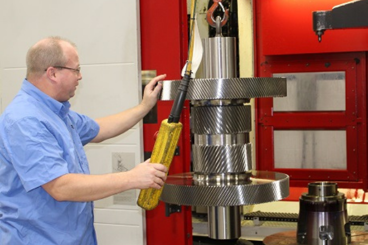 Gear grinding machine refining tooth profiles for precise fit and performance